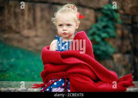 triste ragazza seduta avvolto in una coperta Foto Stock