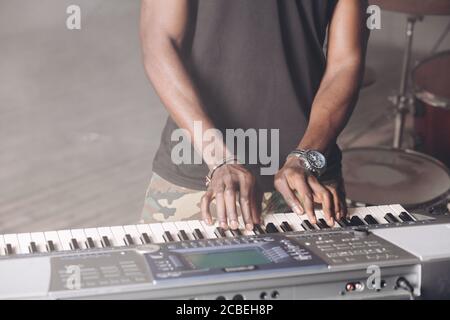 processo di fare musica, suono. primo piano foto ritagliata. mani dell'uomo sulla tastiera. strumento, concetto di instrumentazioni Foto Stock