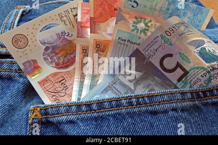 UK Sterling note nel retro di una tasca jeans, cinque sterline, dieci sterline, venti sterline, nota, economia nera, pagamento, Scozia, denaro scozzese Foto Stock