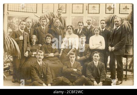 All'inizio del 1900 'cartolina originale di gruppo rilassato di persone, giovani uomini e donne, in grande serra, palme tropicali / felci osteria, di una casa di famiglia ricca, circa 1913, U.K Foto Stock