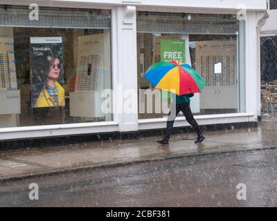 Cambridge, Regno Unito. 13 Agosto 2020. La gente fuori dentro nel tempo bagnato come la pioggia torrenziale e le tempeste di tuono segnalano la fine alla recente ondata di caldo nell'est dell'Inghilterra. Il caldo tempo nel Regno Unito negli ultimi giorni sta arrivando ad un termine come più pioggia e tempeste è previsto nel corso del fine settimana. Credit: Julian Eales/Alamy Live News Foto Stock