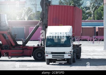 I camion vengono a prendere i contenitori nel porto. Foto Stock