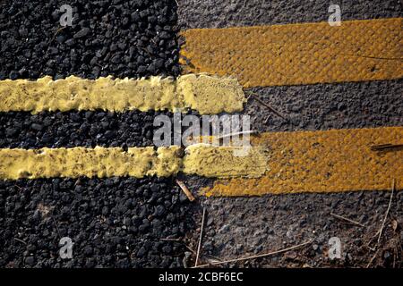 Un primo piano di segnaletica stradale con doppia linea gialla a lato del marciapiede Foto Stock