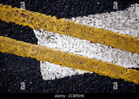 Un primo piano di doppia linea gialla e strada bianca contrassegni Foto Stock