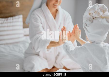 donna caucasica e bambina si siedono giocando a mani aggrappate insieme, famiglia amichevole Foto Stock