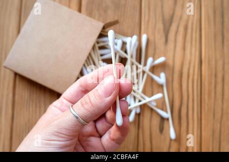 Bastoncino di cotone in mano. Pulizia eco-compatibile delle orecchie e stick di bellezza. Foto Stock