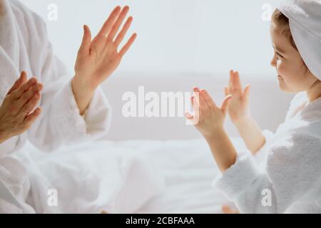 donna caucasica e bambina si siedono giocando a mani aggrappate insieme, famiglia amichevole Foto Stock