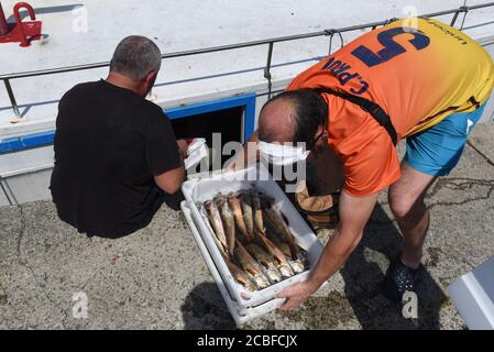 I pescatori sono visti lavorare in o Grove port.o Grove è un villaggio di pescatori che si trova sulla foce dell'estuario di Arousa, la regione della Galizia. Le sue popolazioni vivono principalmente di raccolta di molluschi e di pesca in acque poco profonde, l'allevamento di cozze, ostriche e capesante su piattaforme di legno fuori in acqua. Il turismo è un'altra importante fonte di reddito per la zona. Foto Stock