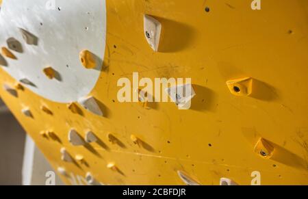 Scatto corto di parete artificiale difficile di roccia con molti piedi e maniglie per problemi di simulazione massi, ambienti sportivi interni, palestra di arrampicata Foto Stock