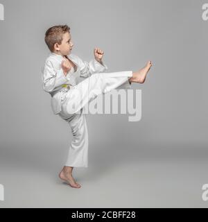 bambino caucasico con kimono pratica kata in arti marziali Foto Stock