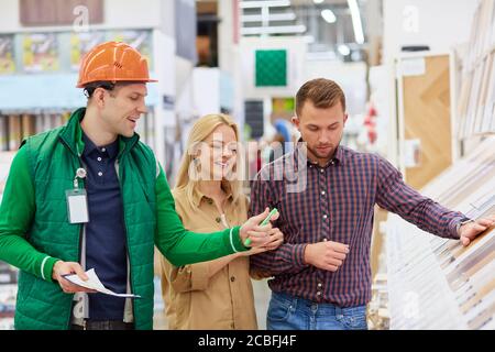 utile lavoratore di magazzino affabile aiutare i clienti con la scelta, uomo uso documento in cui tutte le istruzioni e i vantaggi di merce sono strangati Foto Stock