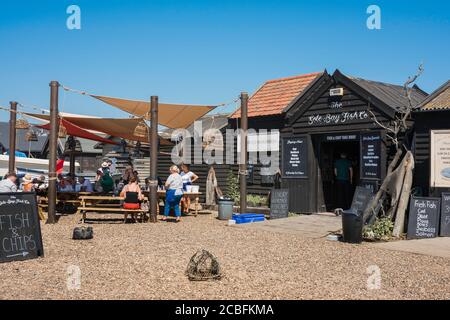 Porto di Southwold, vista in estate di persone seduti ai tavoli fuori del Sole Bay Fish Co Shack mangiare pesce e patatine, Southwold, Suffolk, Regno Unito Foto Stock