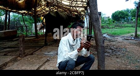 DISTRETTO KATNI, INDIA - 20 AGOSTO 2019: Un uomo indiano villaggio che opera smartphone, concetto per la gente asiatica apprendimento digitale in campagna zona. Foto Stock