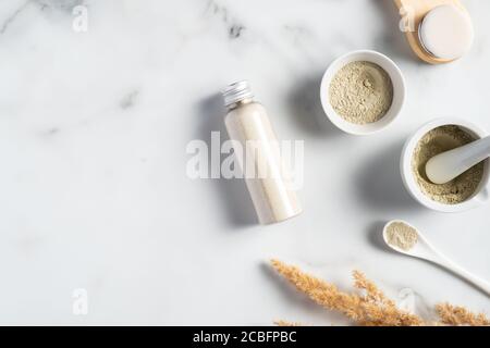 Maschera Ubtan ingredienti, polvere, spazzola per la pulizia del viso su tavolo in marmo. SET di cosmetici naturali SPA. Foto Stock