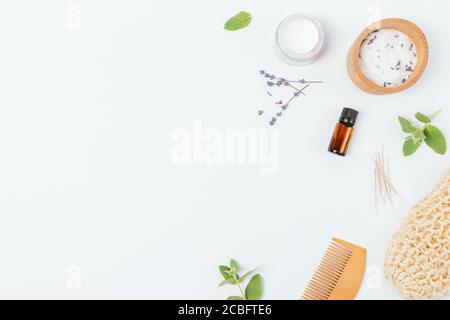 Cosmetici per la cura della pelle a posa piatta con olio all'aroma di lavanda e accessori da bagno naturali su sfondo bianco con spazio per la copia. Foto Stock