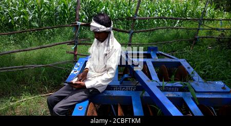 DISTRETTO KATNI, INDIA - 20 AGOSTO 2019: Un povero villaggio indiano agricoltore uomo funzionamento smart phone concetto per la gente asiatica apprendimento digitale mentre sitti Foto Stock