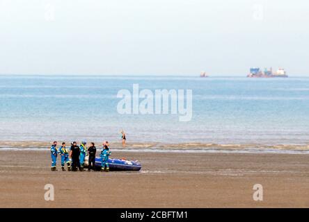 Gli ufficiali della Guardia costiera e della Border Force si trovano vicino ad alcune costolette sulla spiaggia vicina, Greatstone-on-Sea a seguito di un certo numero di piccoli incidenti in barca nel canale all'inizio di oggi. Foto Stock