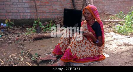 DISTRETTO KATNI, INDIA - 20 AGOSTO 2019: Una donna anziana villaggio indiano che opera il laptop, concetto per l'apprendimento digitale delle persone asiatiche. Foto Stock