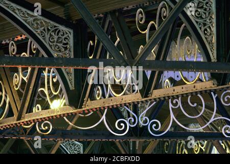 Primo piano della fiammeggiante ironia nella tettoia sopra l'ingresso alla stazione di Brighton. (Fotografato di notte con l'illuminazione della stazione). Foto Stock