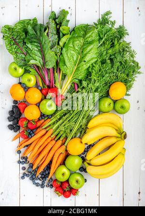 Assortimento di frutta e verdura fresca su tavole di legno bianco. Foto Stock