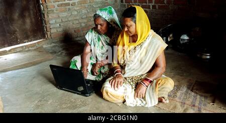 DISTRETTO KATNI, INDIA - 16 AGOSTO 2019: Due donne del villaggio indiano che operano il laptop alla casa povera. Concetto di apprendimento tecnologico Villager. Foto Stock