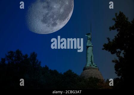 Ripresa notturna composta dell'Hermannsdenkmal con una luna surreale grande. Fotomontaggio. Elementi di questa immagine forniti dalla NASA Foto Stock