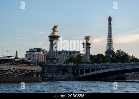 Vista dal fiume senna al ponte più ornato e stravagante della città Pont Alexandre III e le sue torri giganti con Pegasus dorato e un Restaurant Flow Foto Stock