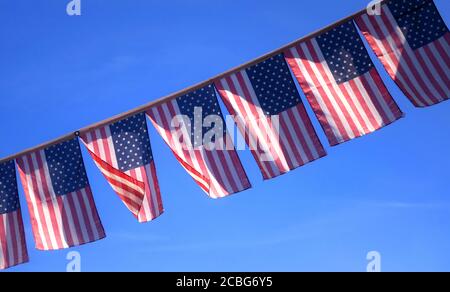 Bandiere americane che si flettono nel Breeze contro un cielo blu Foto Stock