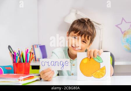 Ragazzo sorridente in classe di sviluppo con parola e scheda oggetto Durante la terapia con ABA Foto Stock