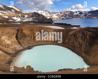 Vista sul cratere di viti della Caldera di Krafla con il lago geotermico e le montagne in lontananza Foto Stock