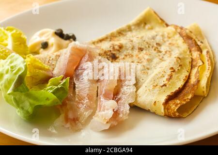 Gravlax con pancake servita foglie di insalata Foto Stock