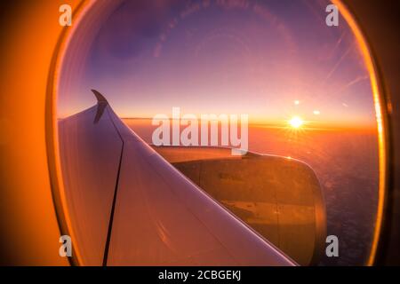 Splendida vista panoramica sulla città del tramonto attraverso la finestra dell'aereo. Bellissimo tramonto, cielo la vista dall'alto, aereo volo vista dall'interno finestrino aereo Foto Stock