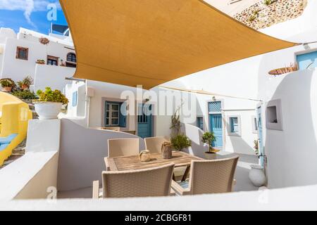 Tranquilla e rilassante terrazza ristorante di fronte alla spiaggia sull'isola di Santorini. Sedie a sdraio con vista sulla caldera, il villaggio di Oia Santorini Foto Stock