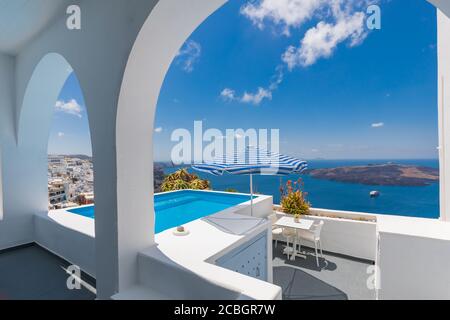 Vacanze di lusso in Grecia a Santorini. Architettura bianca, sedie con vista mare e ombrellone con piscina infinity vuota Santorini. Vacanze estive, vacanze Foto Stock