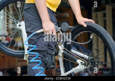 guy pompa una ruota di bicicletta con un compressore Foto Stock