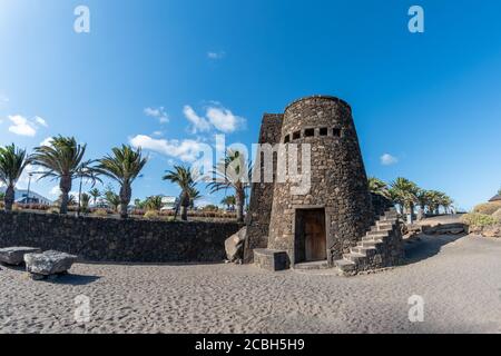 Piccolo castello in pietra sulla spiaggia, belle palme, Costa Teguise sull'isola di Lanzarote, Spagna Foto Stock