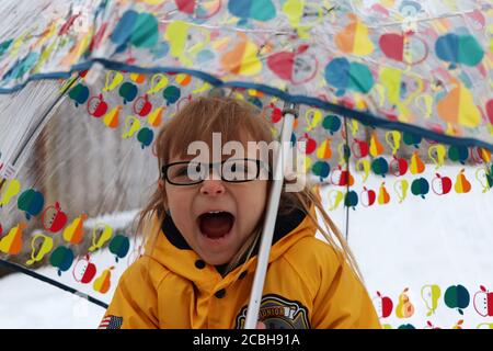 Bambino sotto ombrello nella neve Foto Stock