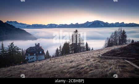 Tramonto invernale in montagna con casa solitaria Foto Stock