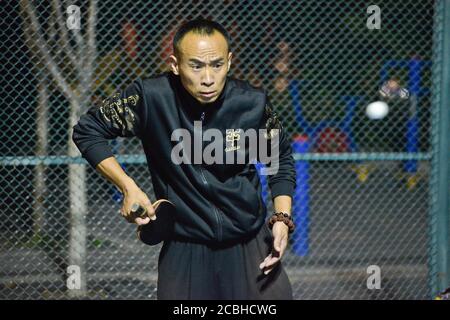 Uomo cinese che gioca a ping pong in un parco pubblico, Pechino, Cina Foto Stock