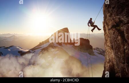 Epico avventuroso Extreme Sport composito di Rock Climbing Man Rappelling Da una scogliera Foto Stock