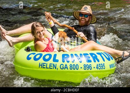 Felice coppia tubing sul fiume Chattahoochee con il loro cane nelle montagne della Georgia del Nord a Helen, Georgia. (STATI UNITI) Foto Stock