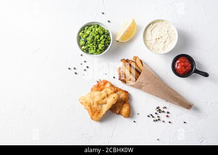 Pesce fritto e patatine in un cono di carta su bianco sfondo con tutti i componenti ricetta classica takeaway cibo vista dall'alto sfondo con trama in pietra bianca Foto Stock