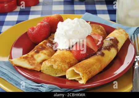 Crepes dorato con fragole fresche e salsa al cioccolato Foto Stock