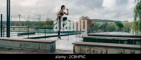 Ragazza saltando sulle panchine facendo formazione Foto Stock