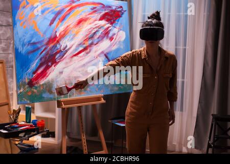 Artista creativo su tela di realtà virtuale con visore vr. Opere d'arte moderne dipingono su tela, opere d'arte creative, contemporanee e di successo Foto Stock