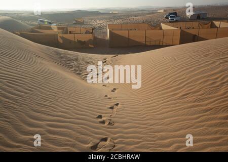 Una vista ipnotizzante delle dune di sabbia ondulate nel deserto, catturando i motivi naturali e le texture create dal vento. I toni caldi sono evidenziati Foto Stock