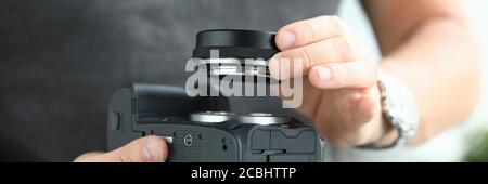 Mani maschili che indossano un moderno adattatore per obiettivo per fotocamera digitale Foto Stock