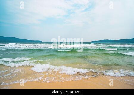 spiaggia, sabbia bianca, acque blu dell'oceano e lussureggiante giungla tropicale, piccole isole verdi all'orizzonte. Foto Stock