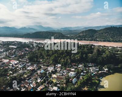 Luang Prabang, Laos. Vista aerea della città di Luang Prabang in Laos. Cielo nuvoloso su una piccola città circondata da montagne. Traffico auto e fiume Foto Stock
