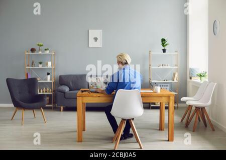 Lavorare da casa. Vista posteriore di un ragazzo che utilizza un computer portatile per videochiamare online o per una conferenza Web con un collega Foto Stock